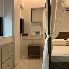 Another angle of the bohemian bedroom in Bandra, showing the four-poster bed and simple, elegant side tables. The design focuses on creating a calm and uncluttered space that still feels warm and personal.
