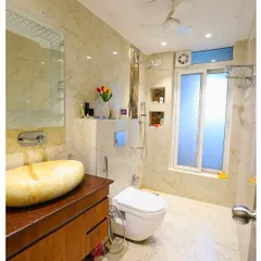 A luxurious bathroom with floor-to-ceiling marble tiles and a unique stone vessel sink. The design feels natural, earthy, and incredibly elegant.