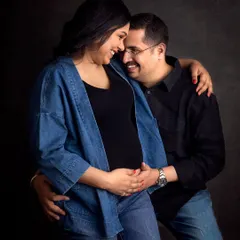 The laughter and love between these two is everything! This candid shot was taken during their denim-themed studio session against a classic dark backdrop.