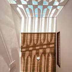 Light is one of our most important materials. Here, a custom-designed geometric skylight casts dramatic patterns across an exposed brick wall, transforming the space and creating a living artwork that changes with the sun.