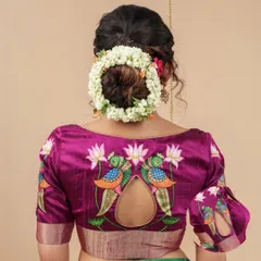 The back of this magenta blouse is a showstopper, featuring a keyhole cutout adorned with hand-painted peacock and lotus motifs.