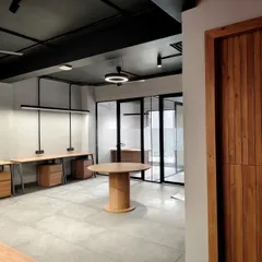 This open-plan office highlights our industrial-chic aesthetic, featuring an exposed ceiling, polished concrete floors, and sleek linear lighting. The layout is intentionally designed to foster collaboration while maintaining a clean, modern, and spacious feel.