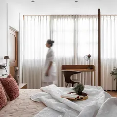 In the master bedroom, my goal is to create a visible hush. This grand four-poster bed, inspired by Kerala’s architectural roots, is balanced by soft sunlight, warm wood, and a palette of layered whites. It is a space designed not just for rest, but for stillness.