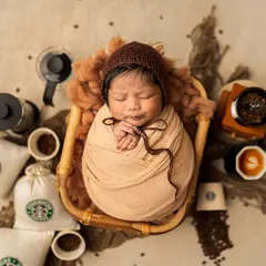 An overhead view of our Starbucks-inspired setup, complete with coffee beans, mini cups, and a very sleepy "little bean" in the center.