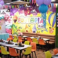 A wider view of the cafe during a mermaid party, showing the ample seating and festive decorations, including hanging lanterns and pennant banners.