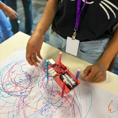 A child at the Yahoo India event watches their newly built Art Bot create a colorful masterpiece. This is the moment of truth, where their hard work pays off in a fun, visual way.