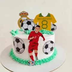 Another angle of the CR7 themed cake, showing the Real Madrid logo and dynamic arrangement of toppers.