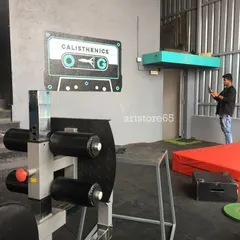 The finished 'Calisthenics OG' cassette tape mural in its gym setting. This type of graphic wall art is perfect for creating photo opportunities and reinforcing the brand identity of a fitness space.