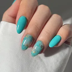 Inspired by the beauty of natural stone, this design features a turquoise marble effect with delicate gold foil flakes. It's a sophisticated and artistic choice for a unique manicure.