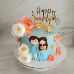 Celebrating an anniversary with a personal touch. This cute cake features hand-drawn style figures of the couple, surrounded by fresh flowers and topped with a custom 'Happy Anniversary' sign.