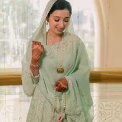 An angelic look for her Nikah ceremony. The bride's mint green outfit is paired with very minimal, clean makeup, highlighting her delicate features and serene expression.