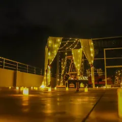Our crazy cabana setup is perfect for a romantic dinner or a surprise proposal. This low-angle shot highlights the path of glowing candles leading to the beautifully lit cabana on a city rooftop at night.
