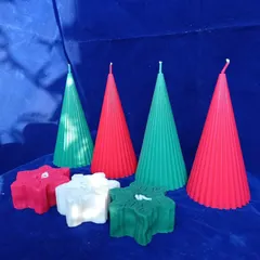 I offer Christmas-themed candles in classic holiday colors. This image shows my cone-shaped ribbed pillar candles and snowflake candles in red, green, and white.