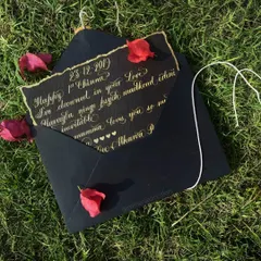 There is something so special about a handwritten letter. This piece, written in shimmering gold ink on textured black paper, shows a personal message for an anniversary. It's a timeless keepsake, perfect for thank you notes, vows, or any heartfelt message you want to preserve.