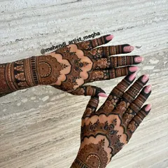 A close-up of the back of the hands, showing how the floral and mandala patterns create a cohesive look. The dark-tipped fingers add a traditional touch to the design.