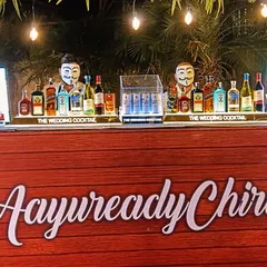 A fun and quirky bar design with a custom 'AayureadyChiru' sign and bartenders in masks, showing how we can adapt to unique party themes.