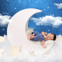 I always capture multiple angles to give you a variety of beautiful shots. This perspective shows the baby peacefully posed on the moon prop, emphasizing their tiny size against the dreamy backdrop.