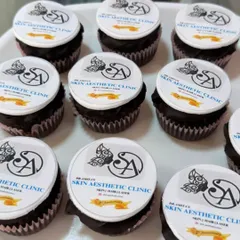Branded cupcakes are a great way to share a sweet treat at company events. Here, I've topped chocolate cupcakes with crisp, edible discs featuring the logo for a skin aesthetic clinic, ensuring perfect brand representation in every bite.