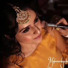 The process of creating a flawless base. Here, I am applying blush to add a natural flush of color to the cheeks for Chinmayi's mehendi look.