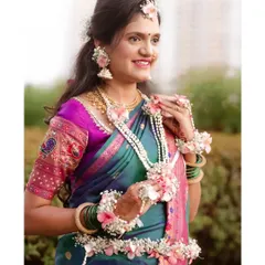 A beautiful portrait of a mother-to-be at her baby shower, adorned in a traditional saree and intricate floral jewelry.