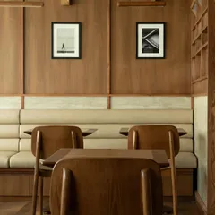 The clean, symmetrical lines of the banquette seating. The neutral upholstery and warm wood create a soothing and harmonious palette, characteristic of the Japandi aesthetic.