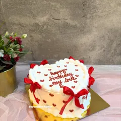 A close-up of my popular vintage-style heart cake. The intricate piping and delicate red bows make it a favorite for birthdays and anniversaries.