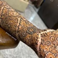 A detailed close-up of the intricate forearm work for engagement bride Zoya. The design features a mix of floral and paisley elements with delicate shading.