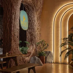 The entrance to Nido, where the nest-like structure made of lantana twigs immediately sets a unique, earthy tone. The warm, layered lighting and rustic wooden furniture welcome guests into a space that feels both grand and intimate.