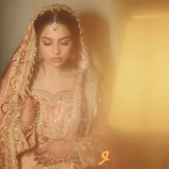 An artistic, dreamy shot of the bride in her magnificent peach and maroon bridal attire.