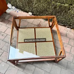 An overhead shot of the coffee table, showing the pattern of the woven cane shelf beneath the glass.