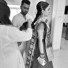 A behind-the-scenes moment from the wedding day. Getting the bride's hair and dupatta just right is a team effort, ensuring she feels confident and beautiful from every angle.