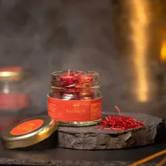 To capture the premium quality of Kashmir saffron, I used a dark, atmospheric setting with subtle smoke. The open jar on a slate tile showcases the vibrant red threads, conveying a sense of luxury and rarity.