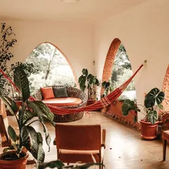An earthy, rustic texture applied to arched walls in a sunroom. This finish complements the natural light and greenery, creating a seamless connection between the indoor and outdoor environment.