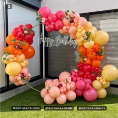 A stunning circular balloon arch in a vibrant sunset palette of orange, yellow, and pink. I added small floral accents to give it a soft, organic touch, perfect for an outdoor celebration.