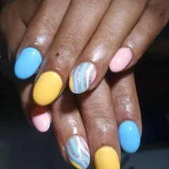 A fun pastel set with a mix of solid colors and a striped glitter accent nail. This shows how we can combine different colors and textures for a unique result.