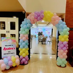 The entrance to Anaira's unicorn party, featuring a beautiful pastel rainbow balloon arch and a personalized welcome sign.