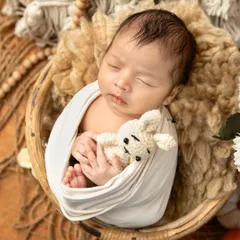 A simple and pure moment of a newborn snuggling with a tiny crocheted teddy bear. I use neutral tones and soft textures in my boho themed setups to keep the focus entirely on your baby.