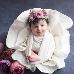 A beautiful newborn girl, wide-eyed and curious, nestled in a floral prop. I love capturing those rare moments when newborns are awake and calm, showing their budding personality right from the start.