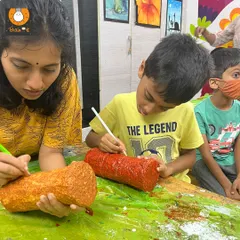 An instructor helps a student paint his handmade rain stick. This project combines building, painting, and learning about the cultural significance of these beautiful instruments.