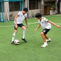 Two older players engage in a one-on-one drill, focusing on offensive and defensive techniques to sharpen their individual game skills for competitive matches.