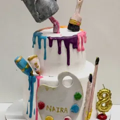 An example of my anti-gravity designs, this art-themed cake features a "floating" paint bucket pouring a colorful drip down the tiers. All the elements, including the palette and brushes, are handcrafted and edible.