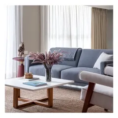 A comfortable and stylish living area setup, featuring a soft blue sofa and a light-toned armchair. The jute rug adds warmth and texture, grounding the space and making it feel homely and calm.