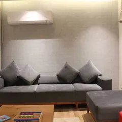 A custom-made grey sofa with a solid wood base, designed for another seating area in the Hyderabad residence. The simple, modern form provides comfortable and stylish seating.