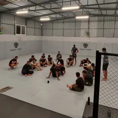 A typical Jiu-Jitsu session at Reign. The coach debriefs the class after a series of hard rolls.