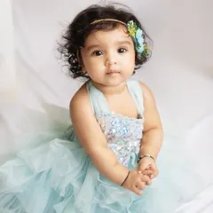 A classic portrait of a beautiful baby girl. Her direct gaze and sweet curls make this a simple yet stunning photo.