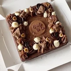 A special brownie slab for a special occasion. This one was customized for a bride-to-be, decorated with rich chocolate swirls, hazelnuts, and a custom chocolate plaque.