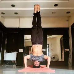 A clear, straight-on view of a tripod headstand, showcasing core strength and stability. This is a foundational inversion we work on in my advanced yoga classes.