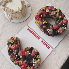 A "60" number cake for a milestone birthday, alongside a vintage-style heart cake. It's a beautiful combination for a big celebration.