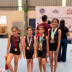 Our talented young female gymnasts displaying their medals from the Infinity Leap Invitational Competition. Their success in all-around, uneven bars, and vault events makes us incredibly proud.