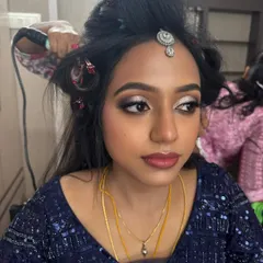 A behind-the-scenes shot of Dr. Akshara's reception makeover. This photo captures the hairstyling process, with her dramatic eye makeup already complete and ready for the final touches.